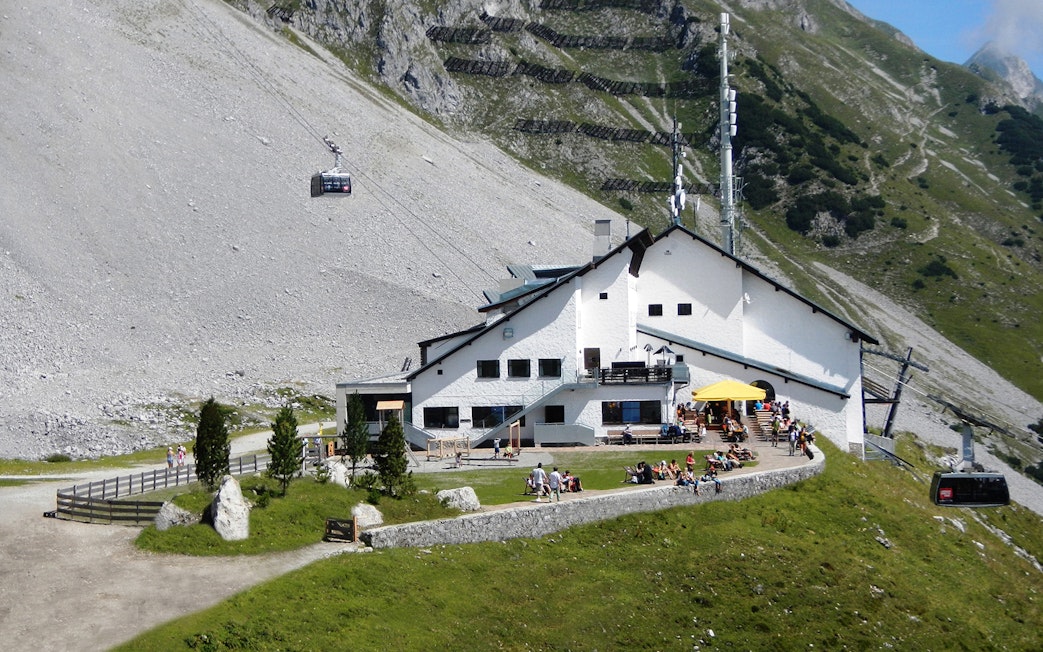 Cable car arriving at mountain station with visitors on terrace, Top of Innsbruck PLUS.