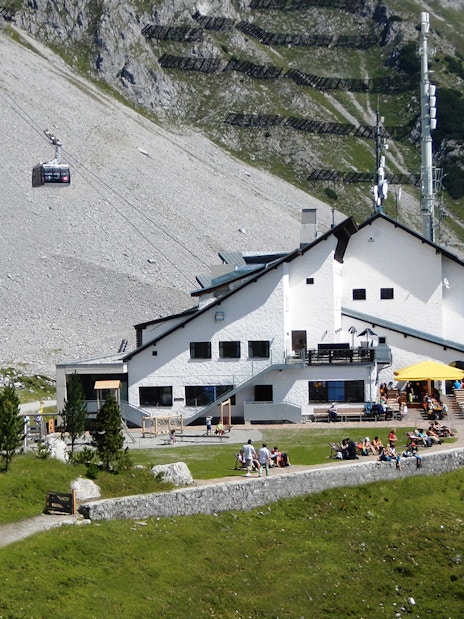 Cable car arriving at mountain station with visitors on terrace, Top of Innsbruck PLUS.