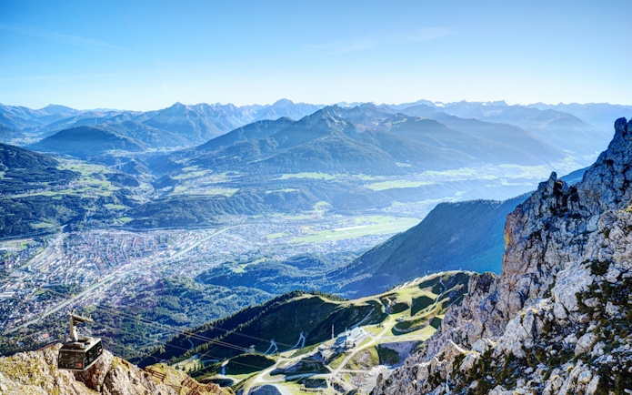 Aerial view of Innsbruck with mountains and a cable car station, Austria.