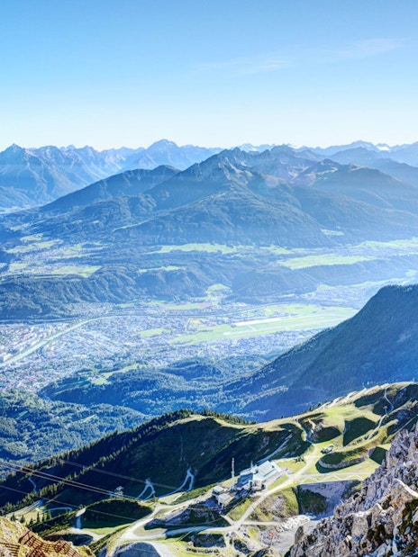 Aerial view of Innsbruck with mountains and a cable car station, Austria.