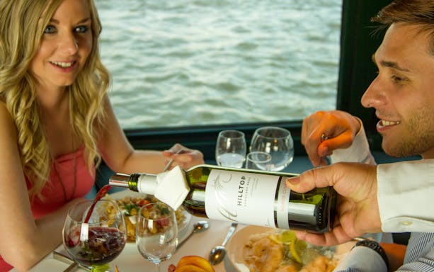 Wine being poured during a Danube cruise dinner with Hungarian cuisine.
