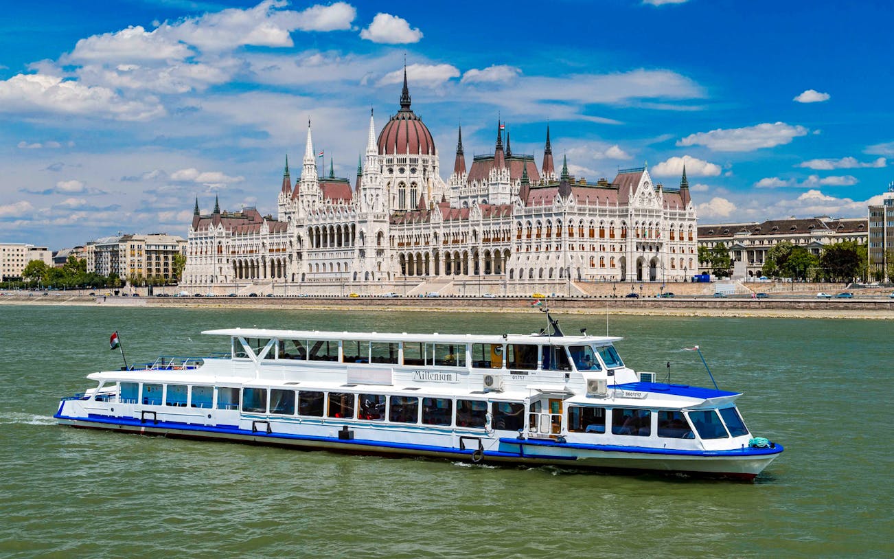 Cruise boat on the Danube River with Budapest Parliament in the background.