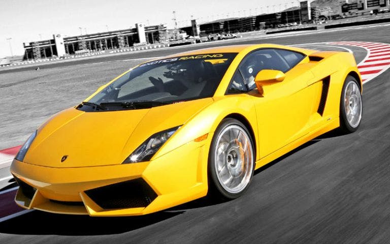 Yellow Lamborghini on a racetrack, showcasing the Drive a Supercar experience.