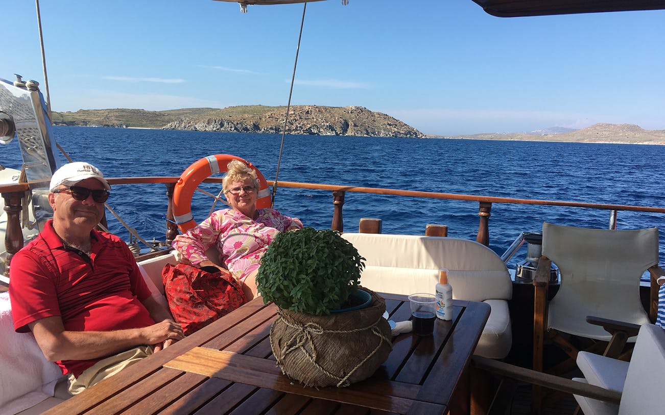 Couple relaxing on a boat during a daily cruise to Delos and Rhenia islands, Greece.