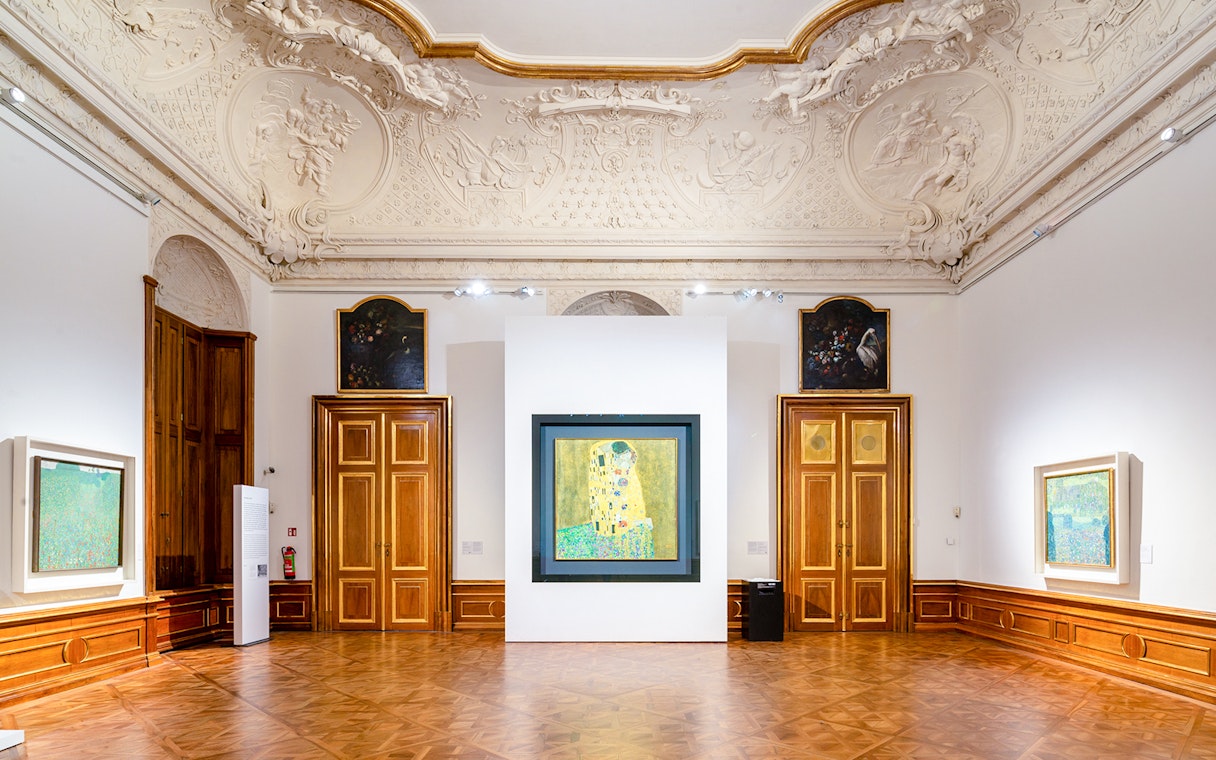 Interior of Belvedere Palace with Klimt's "The Kiss" painting displayed.