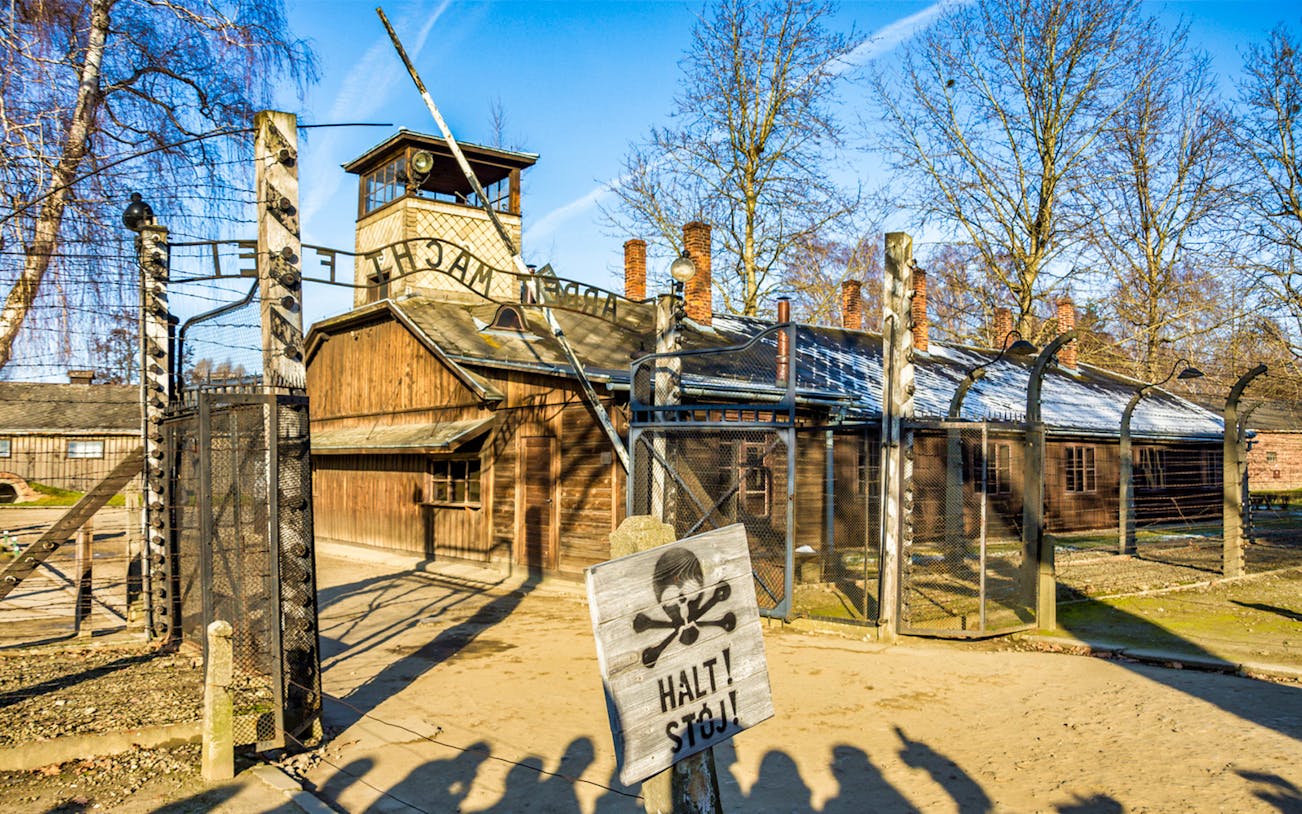 Auschwitz-Birkenau entrance gate with warning sign, part of guided tour from Krakow.