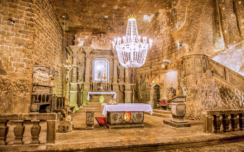 Wieliczka Salt Mine chapel with ornate salt carvings and chandelier.