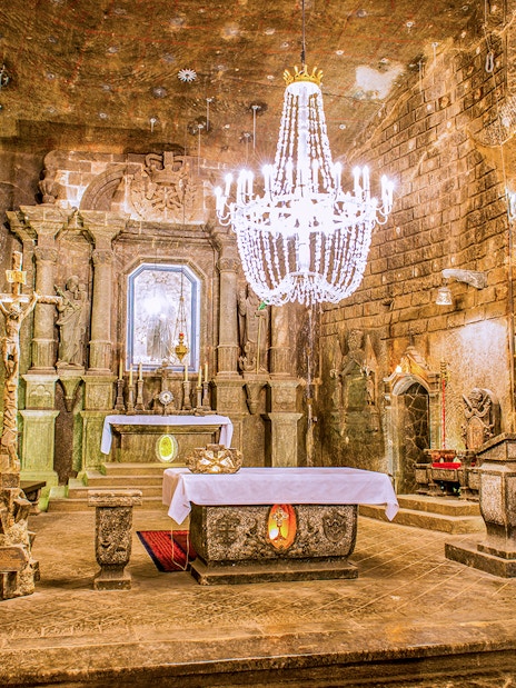 Wieliczka Salt Mine chapel with ornate salt carvings and chandelier.