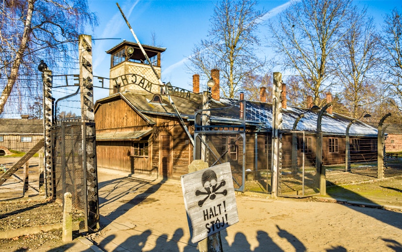 Auschwitz-Birkenau entrance gate with warning sign, part of full-day tour.