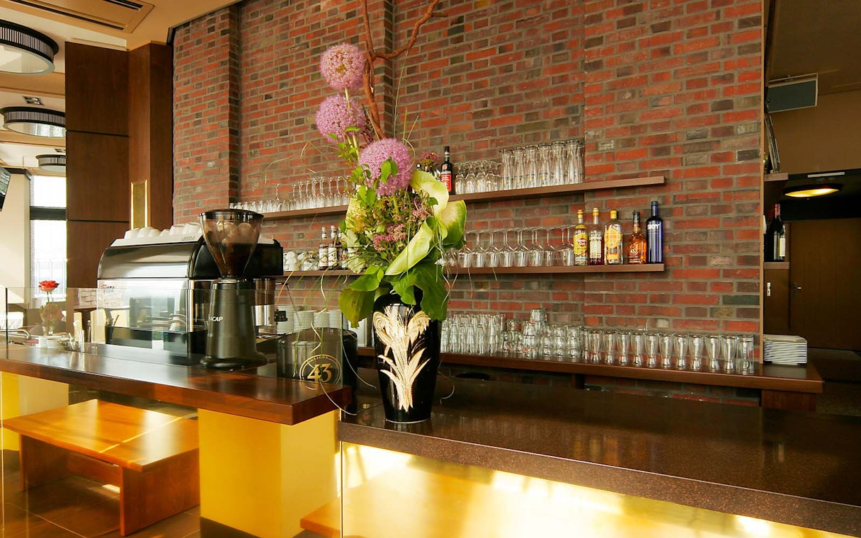 Bar area at Panoramapunkt Berlin with coffee machine and floral arrangement.