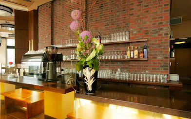 Bar area at Panoramapunkt Berlin with coffee machine and floral arrangement.