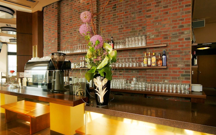 Bar area at Panoramapunkt Berlin with coffee machine and floral arrangement.