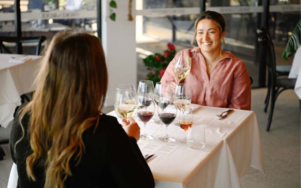 Two people enjoying a wine tasting at Brokenwood winery.