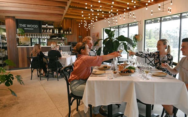 Guests toasting wine at The Wood Restaurant during The Brokenwood Journey tour.