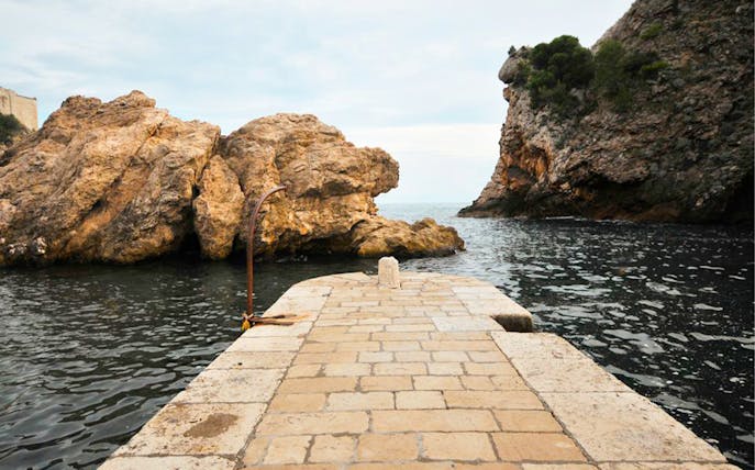 Stone pier leading to rocky coastline on Lokrum Island, Dubrovnik, featured in Game of Thrones.