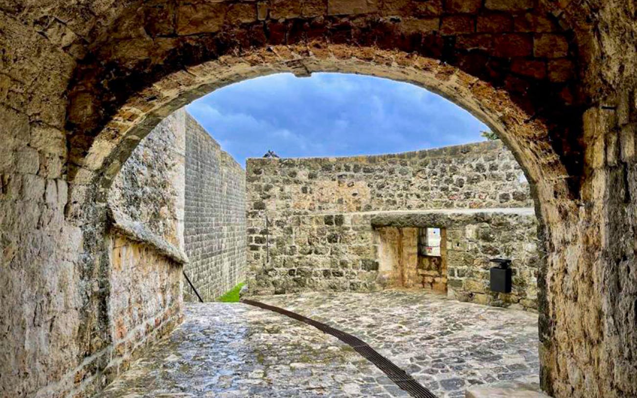 Dubrovnik City Walls archway with stone pathway and sky view.