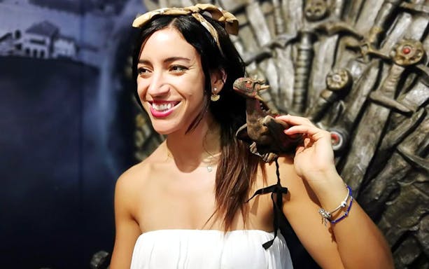 Woman holding a dragon figurine in front of the Iron Throne, Dubrovnik Game of Thrones tour.