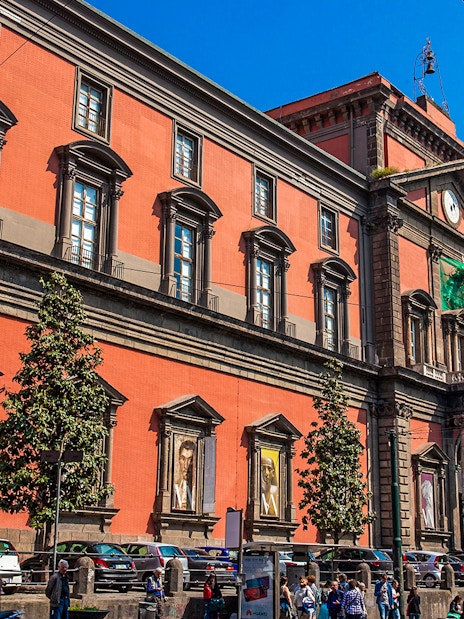 Naples National Archaeological Museum exterior with visitors and parked cars.