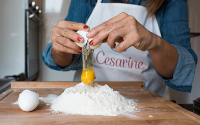 Cracking egg into flour during private cooking class in Bologna.