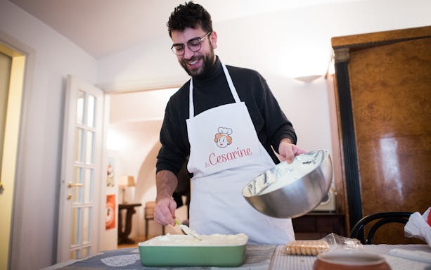 Man preparing dish during private cooking class in Bologna kitchen.