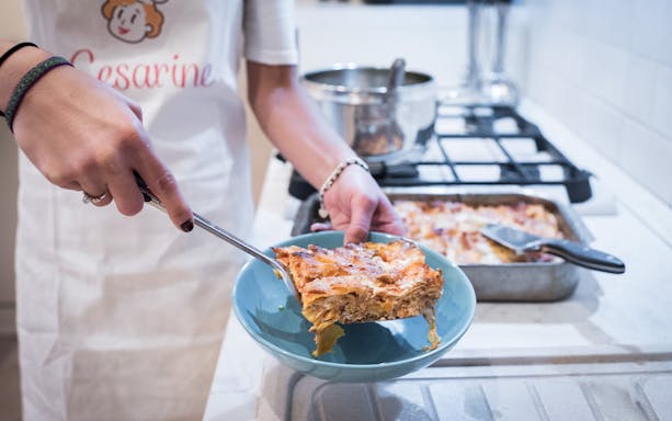 Serving homemade lasagna during a private cooking class in Bologna.