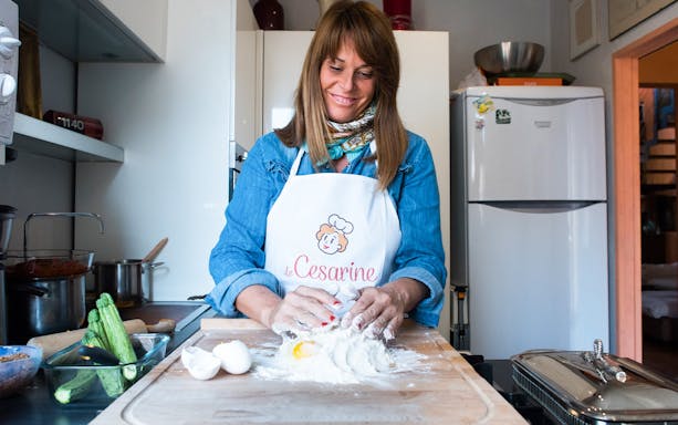 Woman preparing dough in a private cooking class in Bologna kitchen.