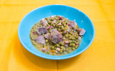 Bowl of traditional Italian peas and pork stew from a cooking class in Bologna.