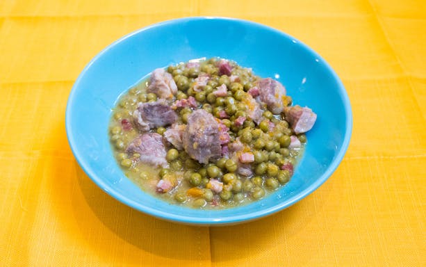 Bowl of traditional Italian peas and pork stew from a cooking class in Bologna.