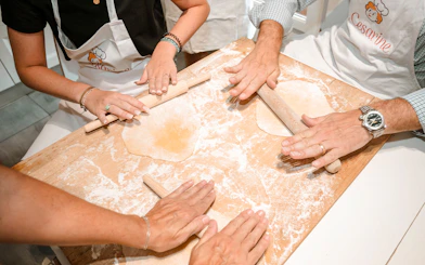 Participants rolling dough in a private cooking class in Rome.