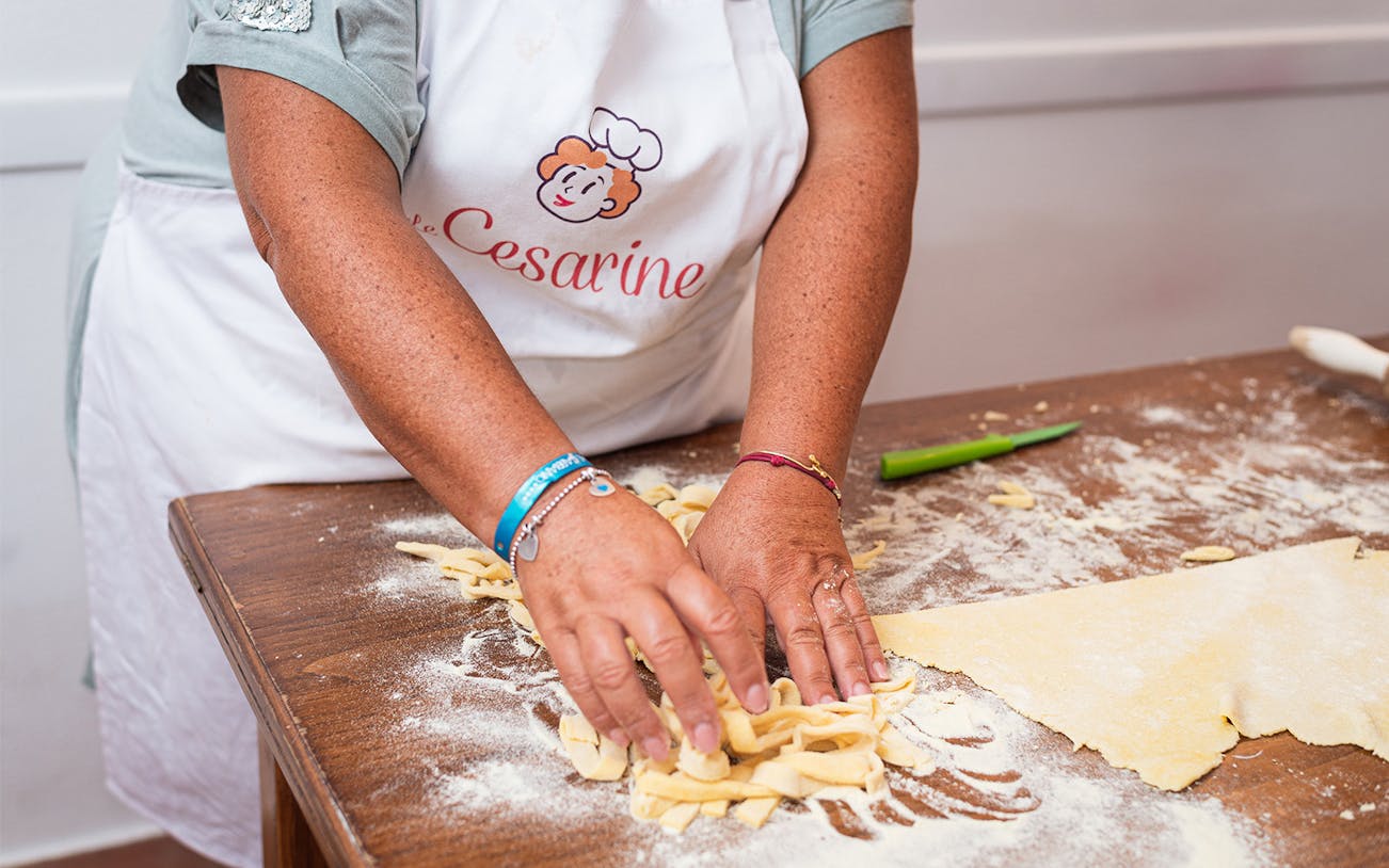 Hands making pasta during a private cooking class in Rome.