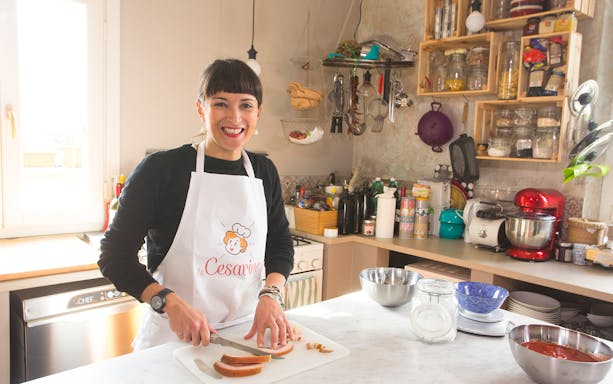 Person slicing bread during a private cooking class in a Rome kitchen.