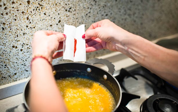 Adding spice to risotto during a private cooking class in Milan.