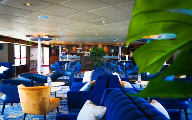 Luxurious seating area on a harbour cruise ship with bar and lounge chairs.