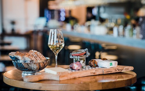Swiss cheese, bread, and wine on a table in a Lausanne restaurant.