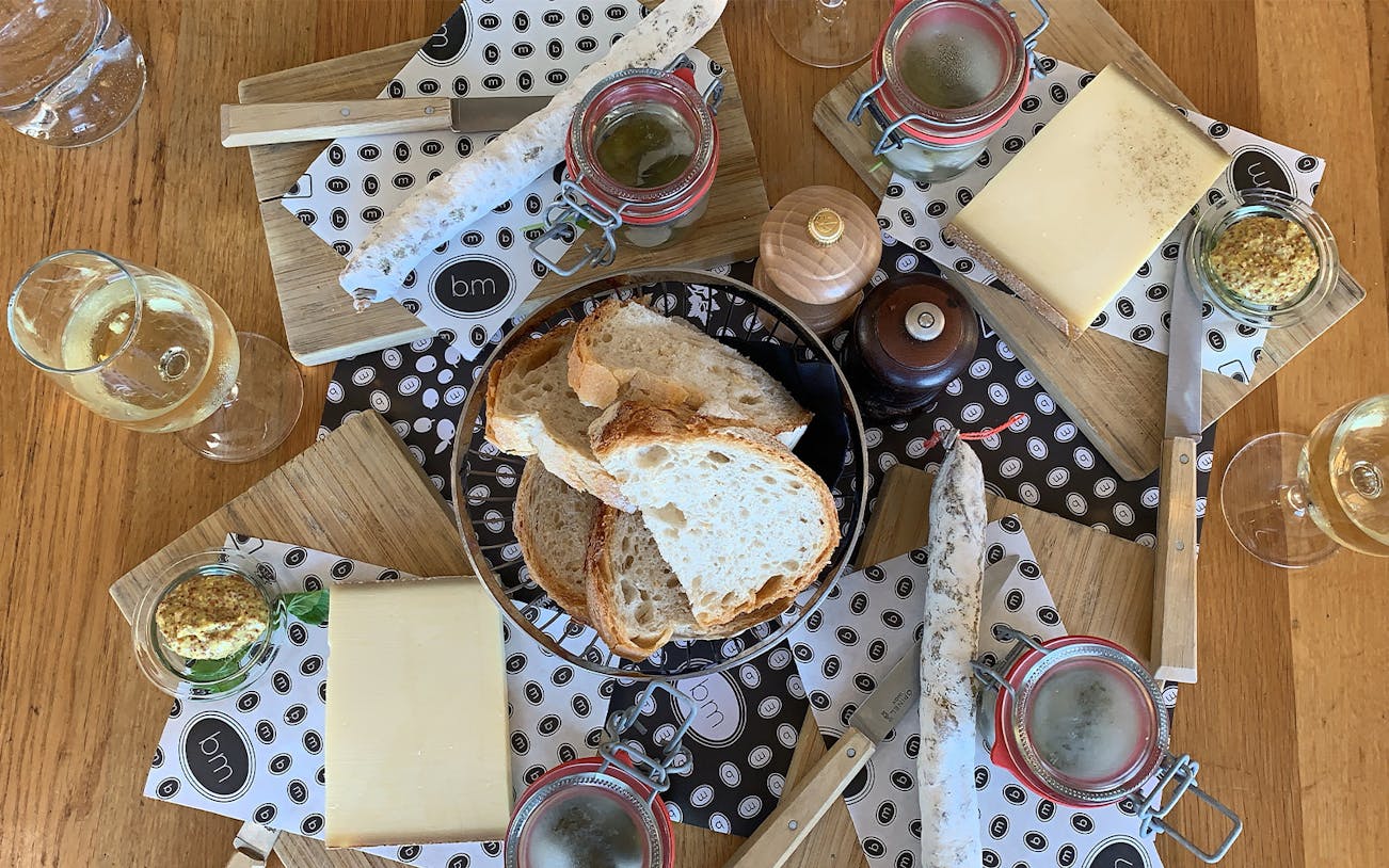 Bread, cheese, and charcuterie with wine on a table in Lausanne, Switzerland.
