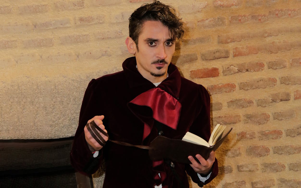 Man in period costume reading from a book during Spanish Inquisition tour in Madrid.
