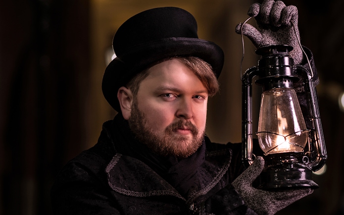 Tour guide holding lantern during Prague Old Town ghost tour.