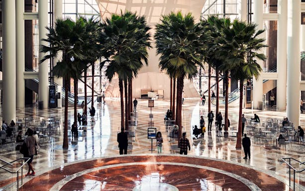 Interior view of Brookfield Place with palm trees, part of the One World Observatory and 9/11 Memorial Walking Tour.