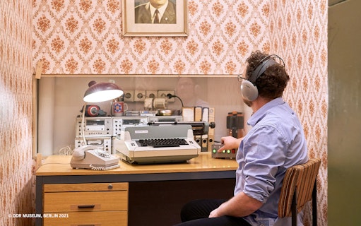 Man using vintage communication equipment at DDR Museum, Berlin.