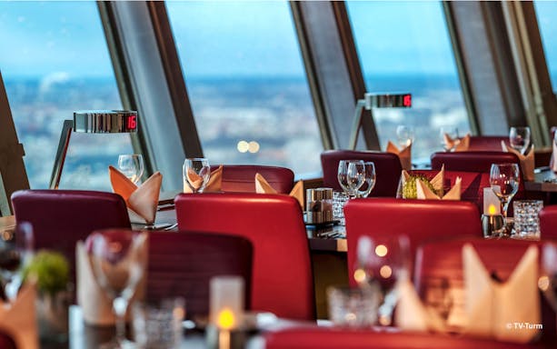 Dining area inside Berlin TV Tower with panoramic city views.
