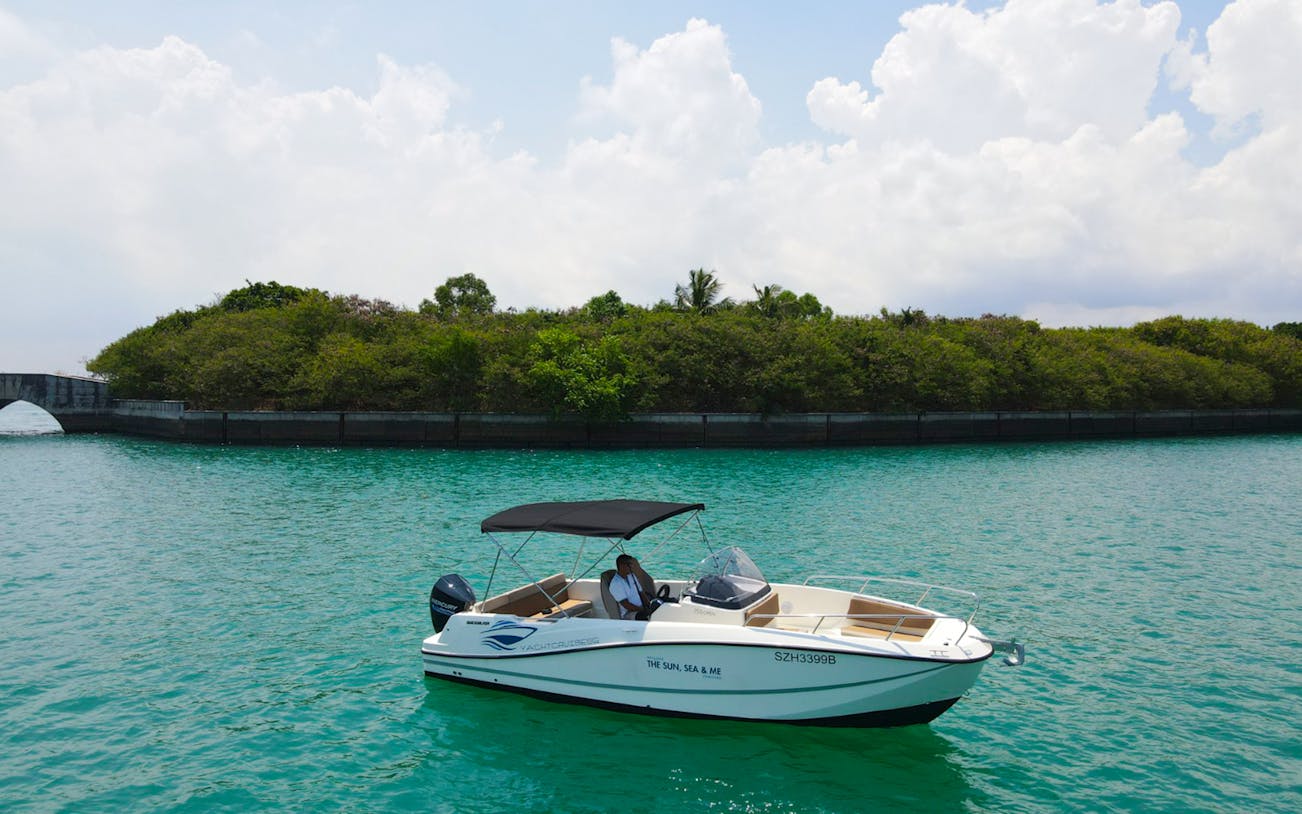 Boat cruising on turquoise water near lush island on Seafarer's Channel Tour.