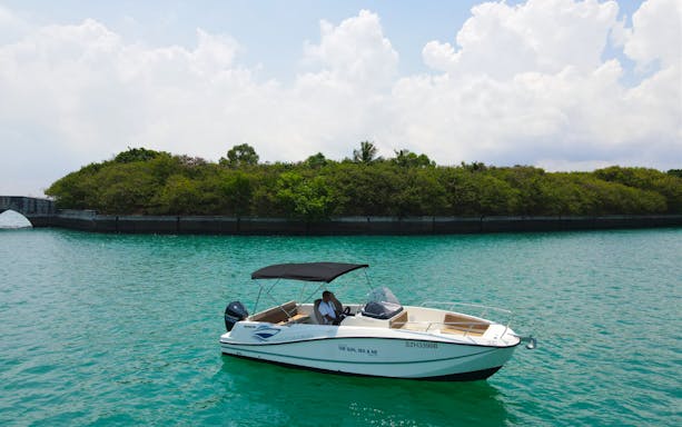 Boat cruising on turquoise water near lush island on Seafarer's Channel Tour.