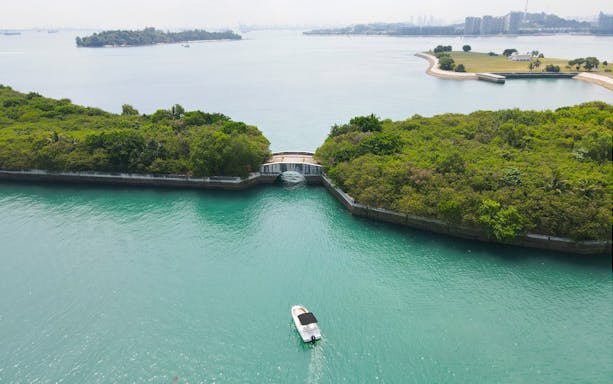 Boat navigating through lush channel on Seafarer's Channel Tour, tropical drink included.