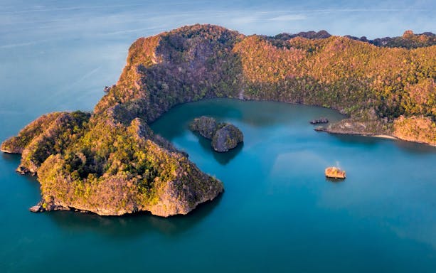 Aerial view of Langkawi Island's lush coastline and turquoise waters during a helicopter tour.