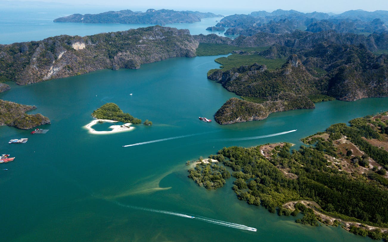 Aerial view of Langkawi Island's lush landscape and turquoise waters during a helicopter tour.