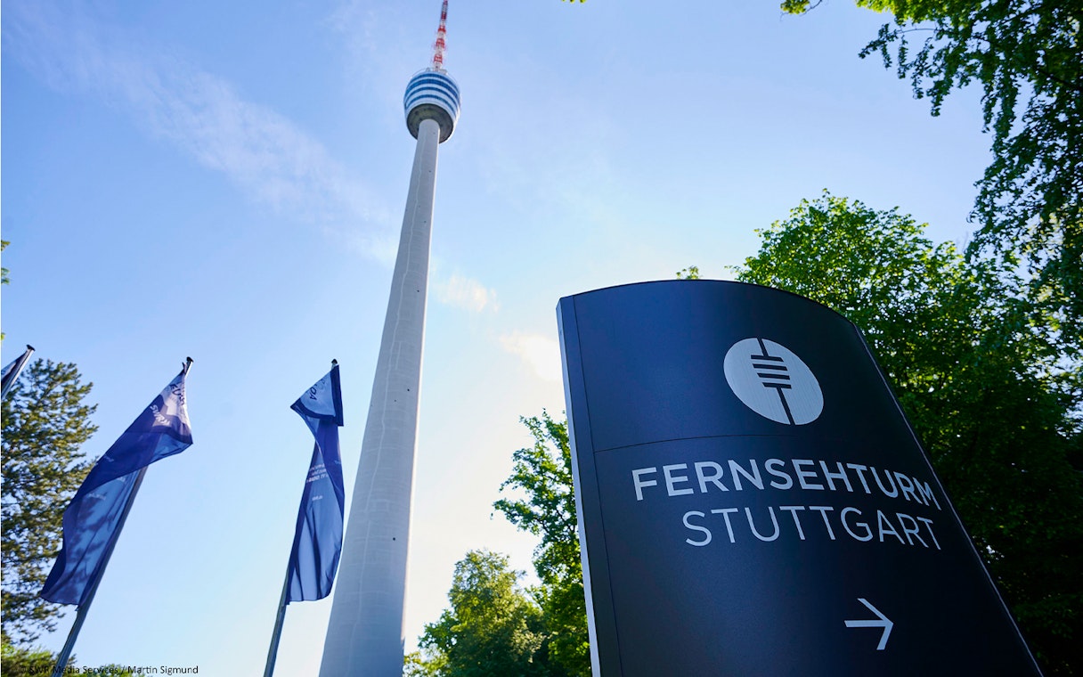 Fernsehturm Stuttgart tower with entry sign and flags in foreground.