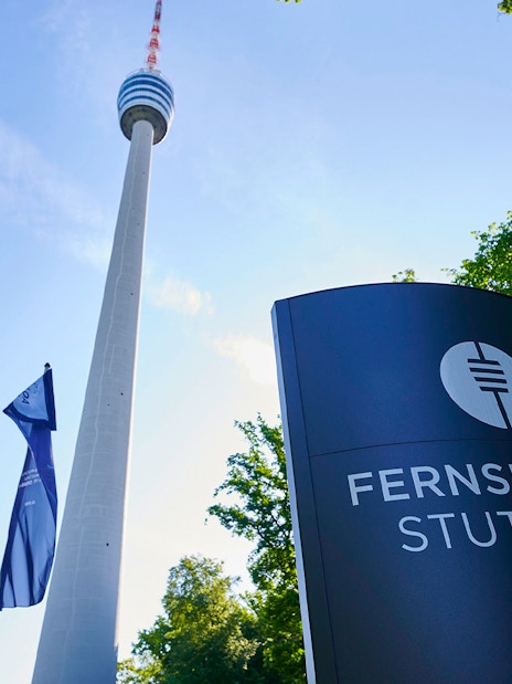 Fernsehturm Stuttgart tower with entry sign and flags in foreground.