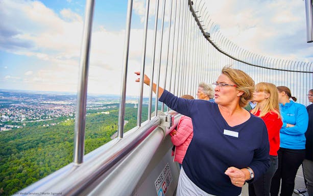 Visitors on the observation deck of Fernsehturm Stuttgart, overlooking the cityscape.