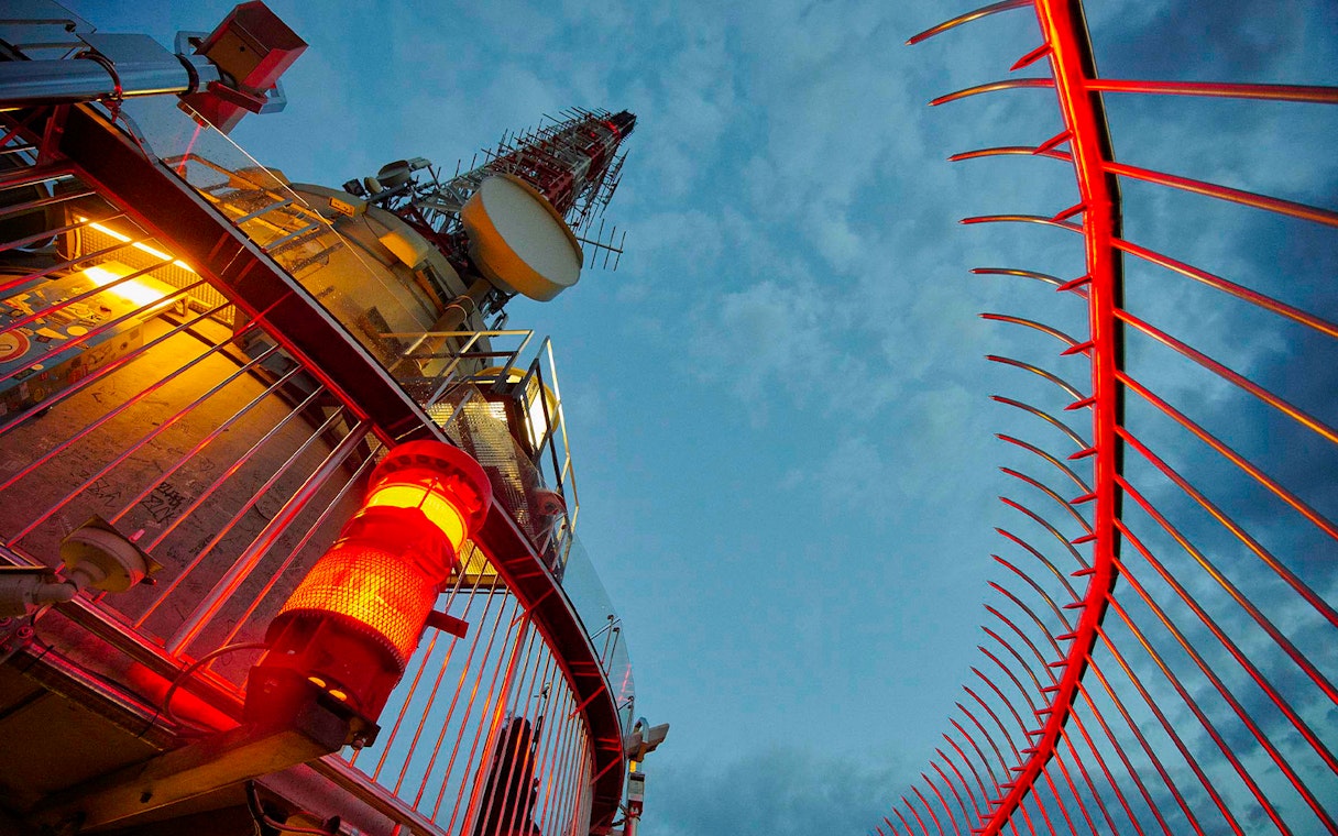 Fernsehturm Stuttgart observation deck with red lights against evening sky.