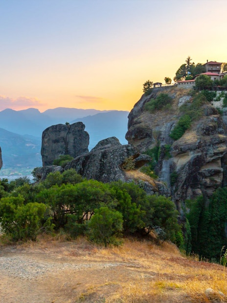 Meteora rock formations and monastery at sunset, Greece, on Hidden Trails Hiking Tour.